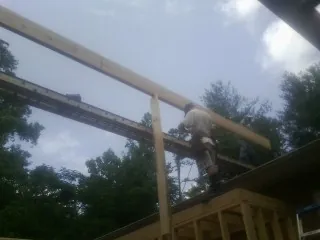 Carpenter setting a ridge beam over a new addition frame — Ice Dam Removal by Roofing Brothers in North Dartmouth
