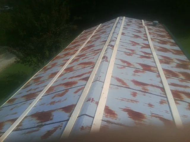 Rusted metal roof panels with new wood purlins before replacement — Storm Damage Roof Repair in North Dartmouth by Roofing Brothers