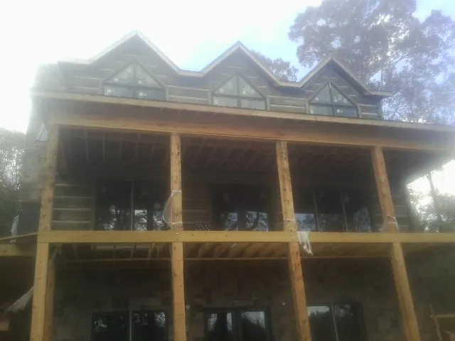 Dormers and porch framing on a large log home under construction — Roof Coating work by our crew in North Dartmouth