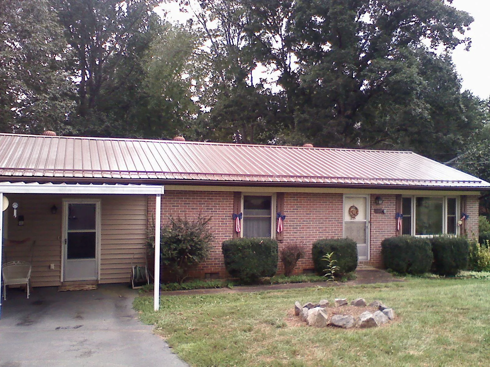Bronze metal roof and carport on a brick ranch home — Roof Repair work by our crew in North Dartmouth